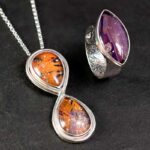 herinneringssieraden-paars-met-oranje Zilveren sieradenset met infinity hanger en ring met handgemaakte steen in paars en oranje